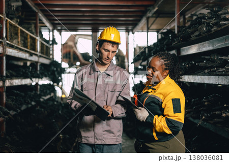 African women with engineer man staff worker working heavy industry old part warehouse African women with engineer man staff worker working heavy industry old part warehouse 138036081