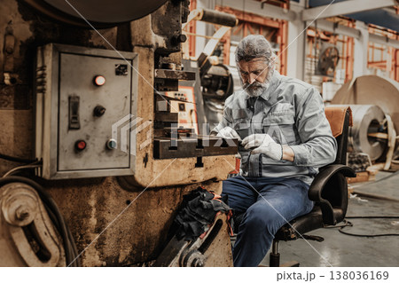 Elderly man hard working, senior old man skill labor hand make metal work piece in heavy industry 138036169