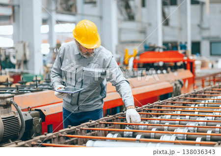 Professional senior Industrial worker in protective helmet and uniform service machinery in factory Professional senior Industrial worker in protective helmet and uniform service machinery in factory 138036343