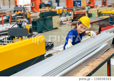 Young Asian woman engineer worker measuring product size, professional work in metal sheet factory Young Asian woman engineer worker measuring product size, professional work in metal sheet factory 138036583