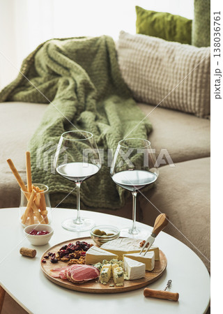 Cozy living room with two glasses of red wine and cheese on table Cozy living room with two glasses of red wine and cheese on table 138036761