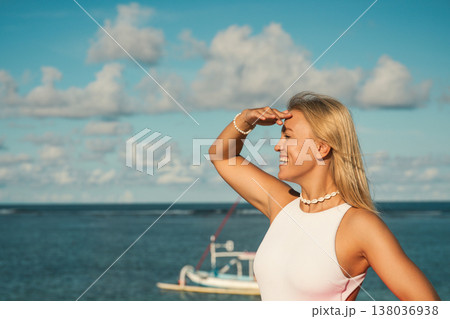 Woman stands by the water while looking at the horizon 138036938