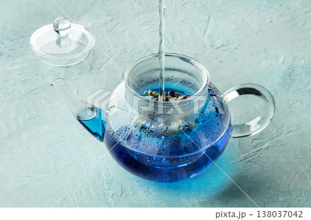 Blue tea, an infusion of butterfly pea flowers, hot water being poured Blue tea, an infusion of butterfly pea flowers, hot water being poured 138037042