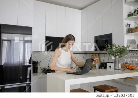 Attractive woman cleaning her laptop at home 138037503