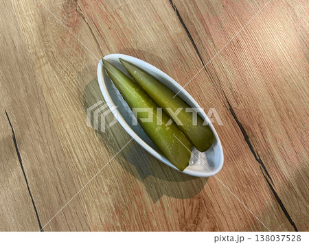a bowl of pickles on a wooden table 138037528