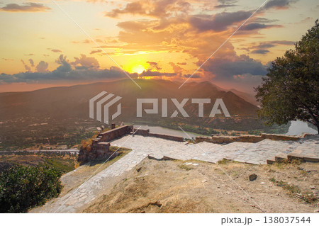 Orange sunset sky in Georgia. Georgian monastery in mountain Orange sunset sky in Georgia. Georgian monastery in mountain 138037544