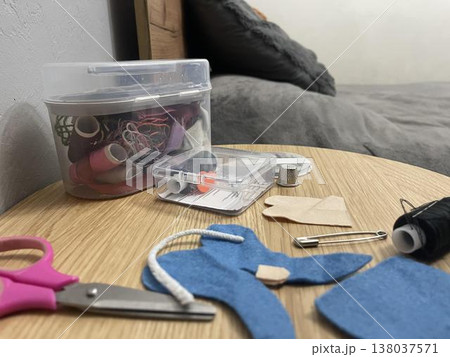A tailor's sewing kit on a table. Needles, thread, and fabric for sewing. A tailor's sewing kit on a table. Needles, thread, and fabric for sewing. 138037571