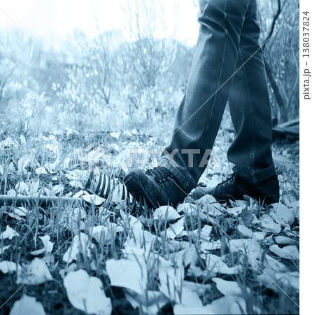 The foot steps on a lying rake 138037824