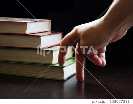 Hand walking on a ladder made of books Hand walking on a ladder made of books 138037851
