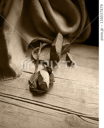 An antique leather sling lies on wooden desk 138037879