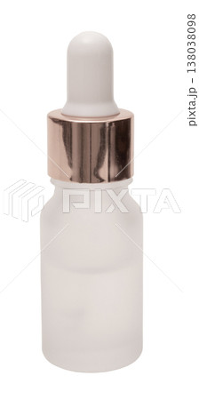 A clear glass dropper bottle with a white dropper top and a metal cap is isolated on a plain white background. This bottle can hold serums or liquids for cosmetic use 138038098