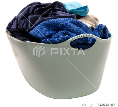 A laundry basket holds a mix of colorful clothes and towels ready for washing. The basket stands alone on a clear background showing various fabric textures A laundry basket holds a mix of colorful clothes and towels ready for washing. The basket stands alone on a clear background showing various fabric textures 138038107