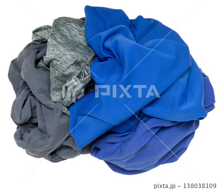 Different colored clothes are wadded together in a messy pile on a plain background. These clothes show a mix of materials and textures, likely from laundry or storage Different colored clothes are wadded together in a messy pile on a plain background. These clothes show a mix of materials and textures, likely from laundry or storage 138038109