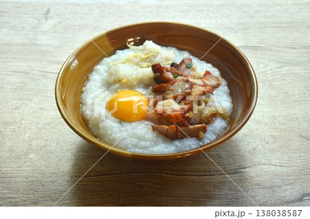 congee or rice porridge soup topping sweet red barbecue pork and egg yolk on bowl 138038587