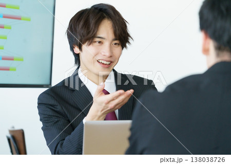 オフィスでミーティングをするスーツ姿の若い日本人男性2人 オフィスでミーティングをするスーツ姿の若い日本人男性2人 138038726
