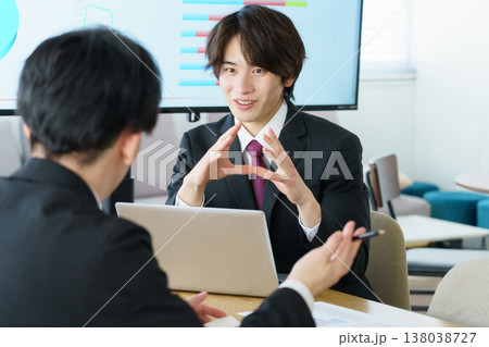 オフィスでミーティングをするスーツ姿の若い日本人男性2人 オフィスでミーティングをするスーツ姿の若い日本人男性2人 138038727
