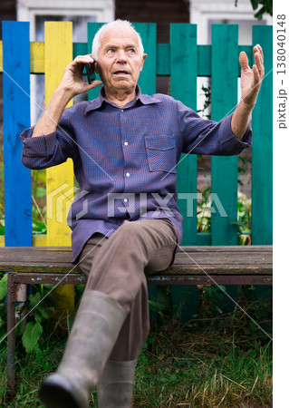 Senior man talking on phone outdoors Senior man talking on phone outdoors 138040148