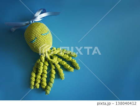 Knitted octopus. Amigurumi. Handmade. Abstract creative background with knitted octopus. Knitted octopus. Amigurumi. Handmade. Abstract creative background with knitted octopus. 138040412