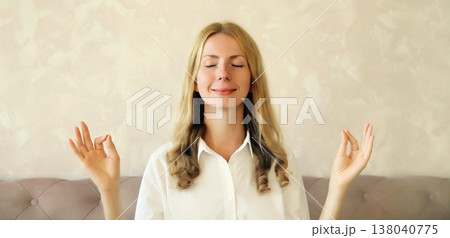 Calm relaxed healthy young woman meditates, girl practicing doing yoga exercises, stress relief 138040775