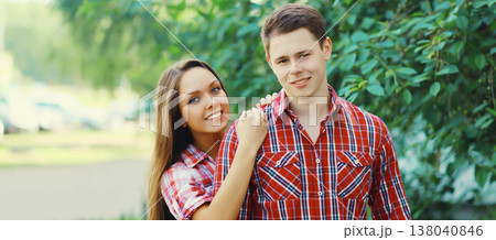 Portrait happy smiling caucasian young couple together outdoors standing in summer park Portrait happy smiling caucasian young couple together outdoors standing in summer park 138040846