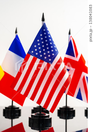 Flags of different countries displayed in a row on a table in a bright setting 138041083