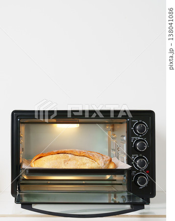 Toaster oven with bread cooking inside on kitchen counter Toaster oven with bread cooking inside on kitchen counter 138041086