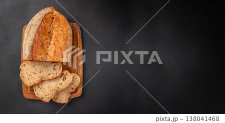 Seeded Bread Loaf with Slices on Wooden Board over Black Background Seeded Bread Loaf with Slices on Wooden Board over Black Background 138041468