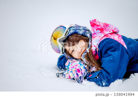 雪の上で寝そべる若い女性 138041994