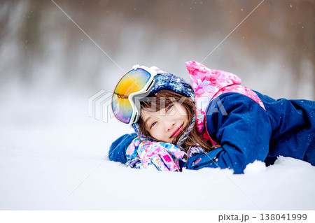雪の上で寝そべる若い女性 138041999