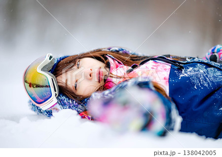雪の上で寝そべる若い女性 138042005
