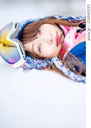 雪の上で寝そべる若い女性 138042015