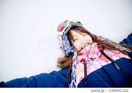 雪の上に寝そべる若い女性 138042102