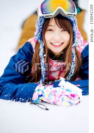 雪の上に寝そべる若い女性 138042109