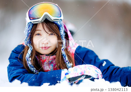 雪の上に寝そべる若い女性 138042113