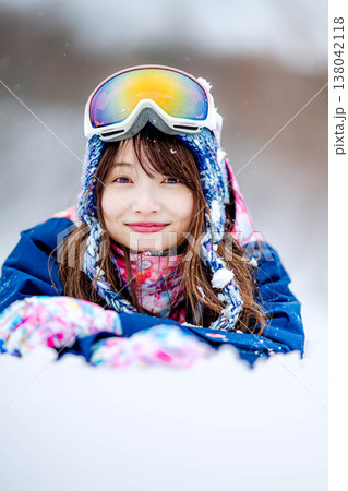 雪の上に寝そべる若い女性 138042118
