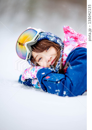 雪の上に寝そべる若い女性 138042135