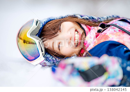 雪の上に寝そべる若い女性 138042145