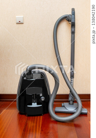 Vacuum cleaner. Black vacuum cleaner on the floor in the apartment. 138042190