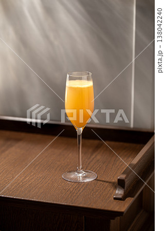 Orange cocktail in champagne glass on wooden table Orange cocktail in champagne glass on wooden table 138042240