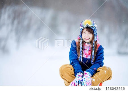 雪の上に座るスキーウェア姿の若い女性 138042266