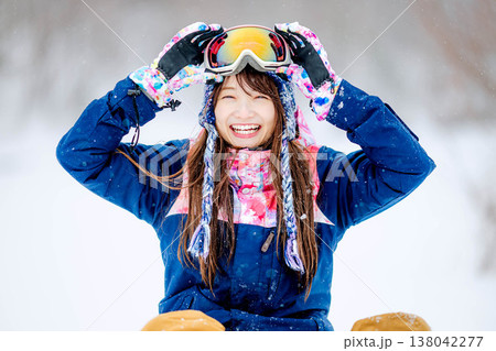 雪の上に座るスキーウェア姿の若い女性 138042277