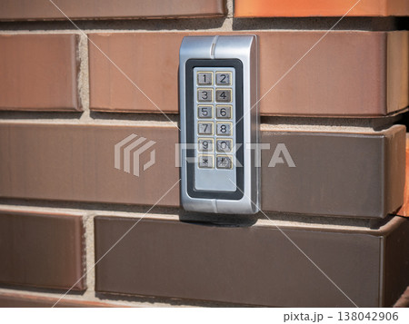 Electronic keypad on brick wall. Digital security device for access control system. Numeric button for password entry and home safety. Modern technology for building entry protection. Electronic keypad on brick wall. Digital security device for access control system. Numeric button for password entry and home safety. Modern technology for building entry protection. 138042906