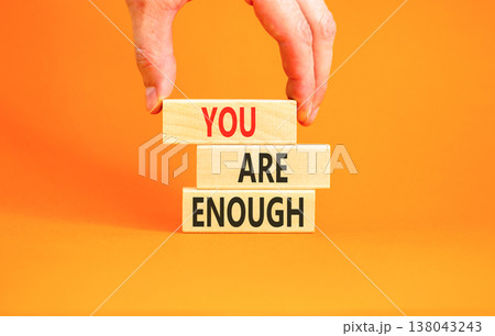 You are enough words symbol. Concept words You are enough on beautiful wooden blocks. Beautiful orange background. Businessman hand. Business motivational and you are enough concept. Copy space. 138043243