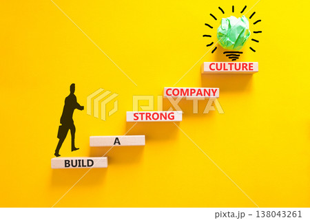 Strong company culture symbol. Concept words Build a strong company culture on beautiful wooden blocks. Beautiful yellow paper background. Business strong company culture concept. Copy space. 138043261