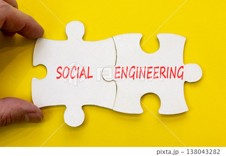 Social engineering words symbol. Concept words Social engineering on beautiful white puzzles. Beautiful yellow background. Businessman hand. Business and Social engineering words concept. Copy space. 138043282