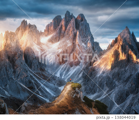 Girl on the mountain peak and amazing high rocks at sunset 138044019