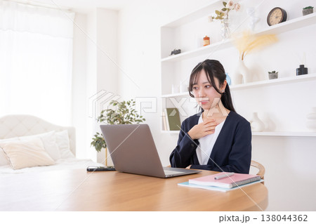 オンライン会議でパソコンに向かって話す20代女性 オンライン会議でパソコンに向かって話す20代女性 138044362