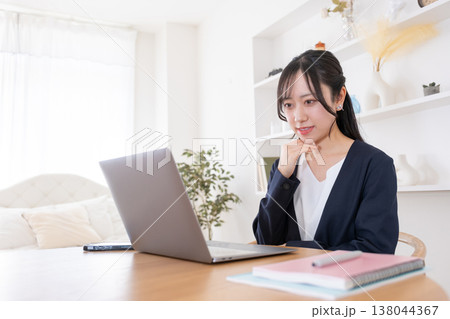 オンライン会議でパソコンに向かって話す20代女性 138044367