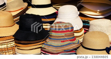 A variety of summer women's hats in a street market. A variety of summer women's hats in a street market. 138044605