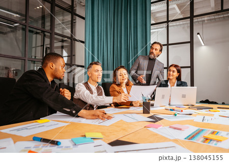 Group of people discussing ideas in a modern office setting during a business meeting in the afternoon 138045155